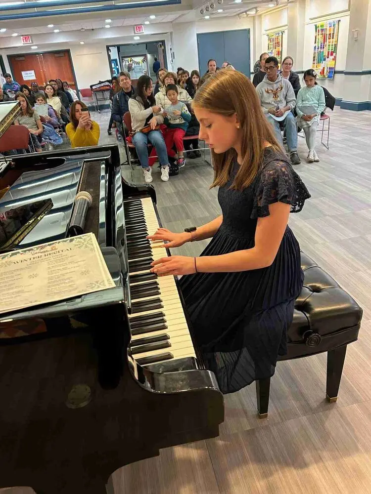 An Allegro Music School student showcases her skills on the piano during the Winter Recital 2024, impressing the gathered audience.